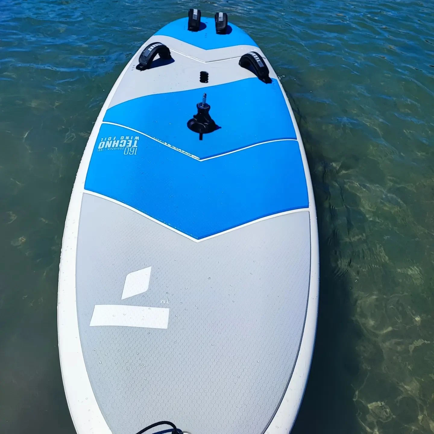 Blue and white SUP board on clear water